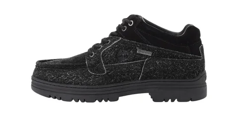 Chaussure noire avec texture laineuse et semelle épaisse.