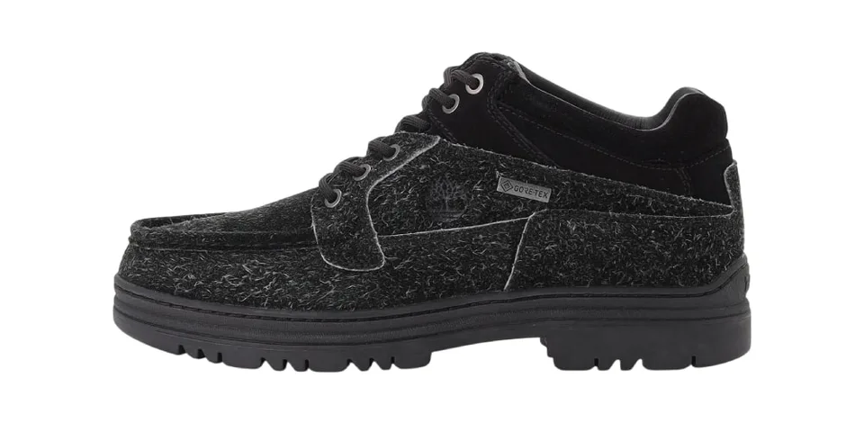 Chaussure noire avec texture laineuse et semelle épaisse.
