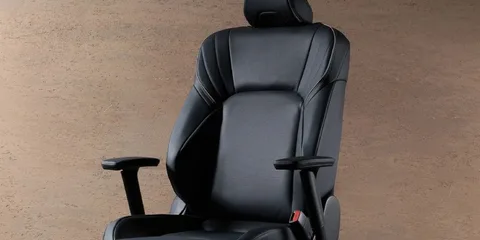 Chaise en cuir noir avec accoudoirs et appui-tête sur fond brun.