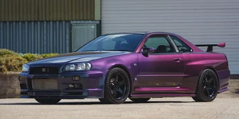 Voiture sport violette stationnée à l'extérieur avec un aileron arrière.
