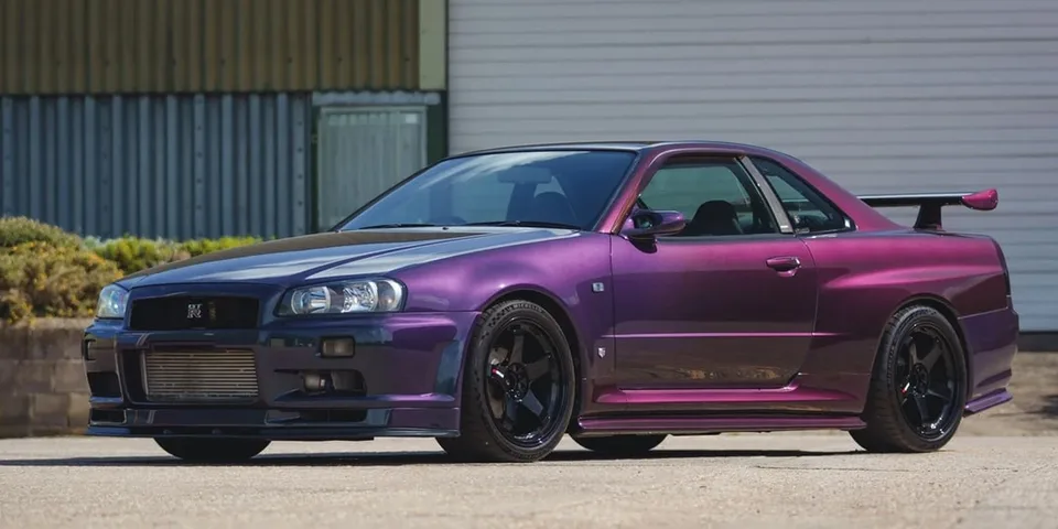 Voiture sport violette stationnée à l'extérieur avec un aileron arrière.