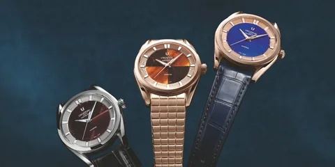 Trois montres élégantes sur fond bleu.