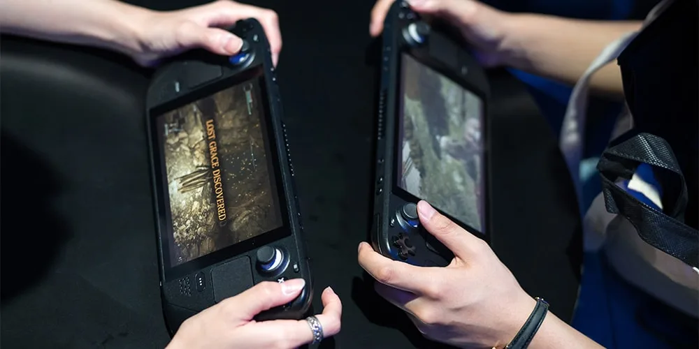 Deux personnes tenant des consoles de jeu portables.