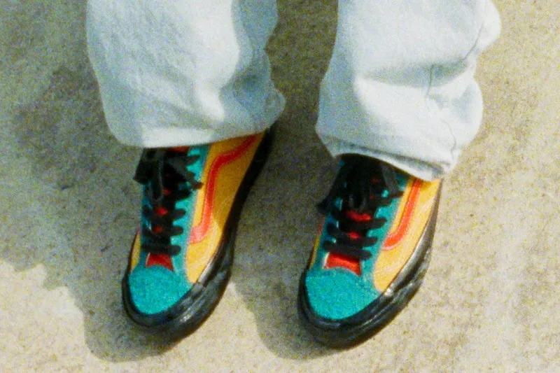 Chaussures colorées et pantalons clairs sur fond de sol.