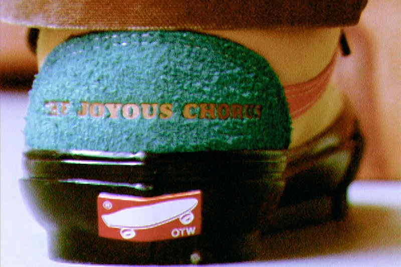 Talon de chaussure avec texte 'THE JOYOUS CHORUS', logo de baignoire dessous.