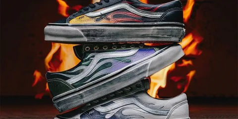 Trois chaussures avec motif de flammes empilées devant un feu.