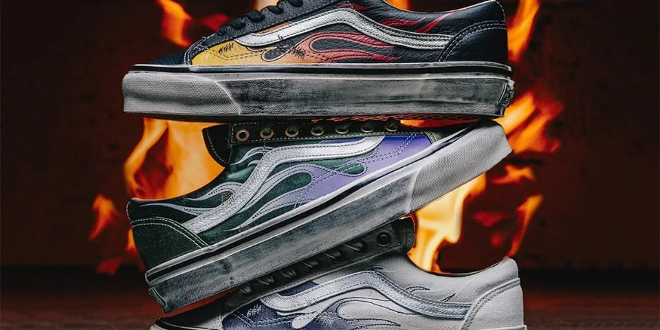 Trois chaussures avec motif de flammes empilées devant un feu.
