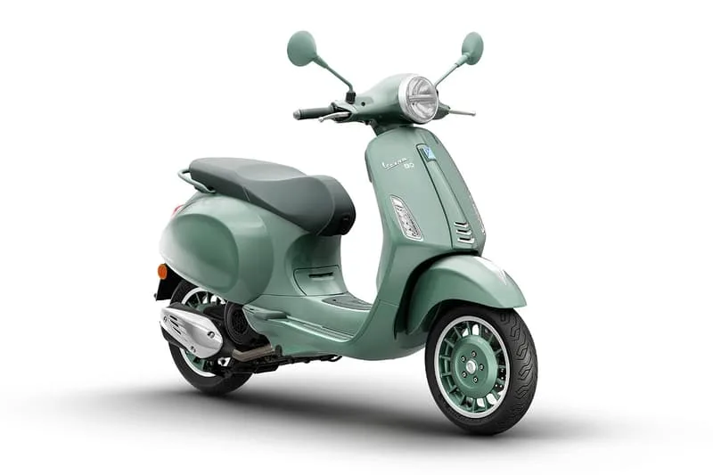 Scooter Vespa verte moderne avec des rétroviseurs et des roues stylées.