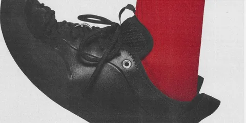 Chaussure noire avec chaussette rouge visible.
