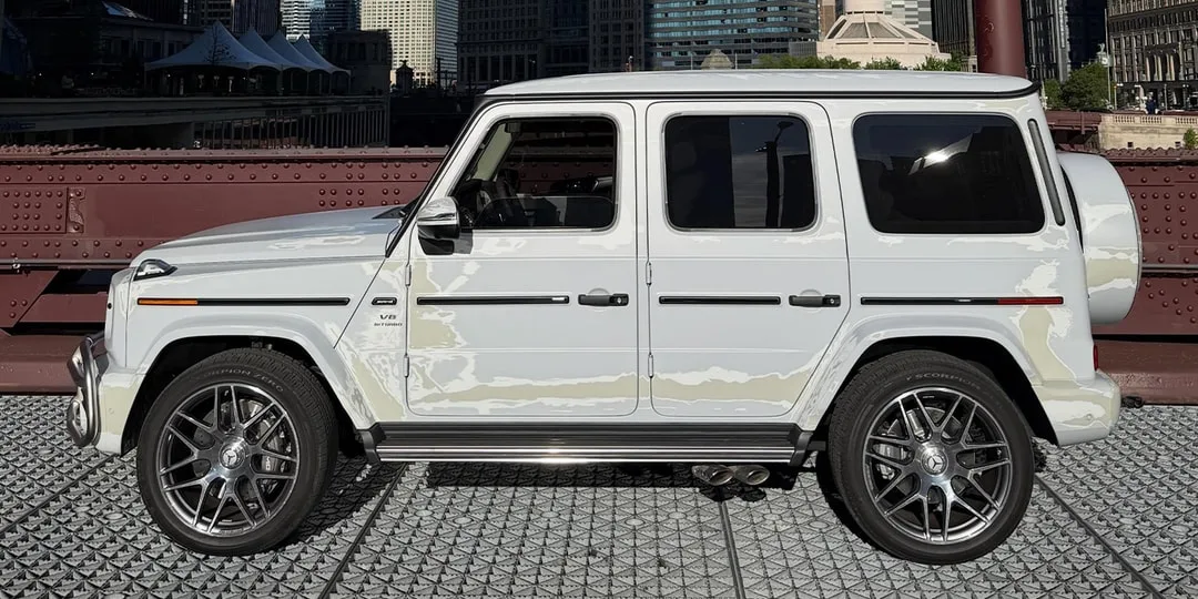 Voiture 4x4 blanche sur un pont en ville.