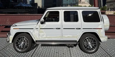 Voiture 4x4 blanche sur un pont en ville.
