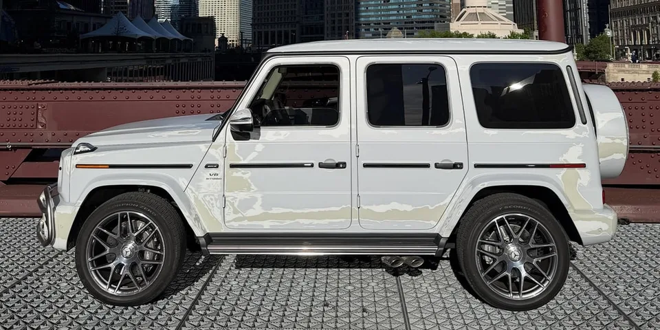 Voiture 4x4 blanche sur un pont en ville.
