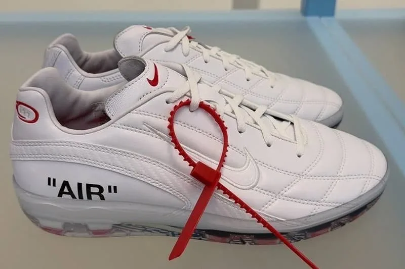 Basket blanche avec étiquette rouge et texte 'AIR' en noir.