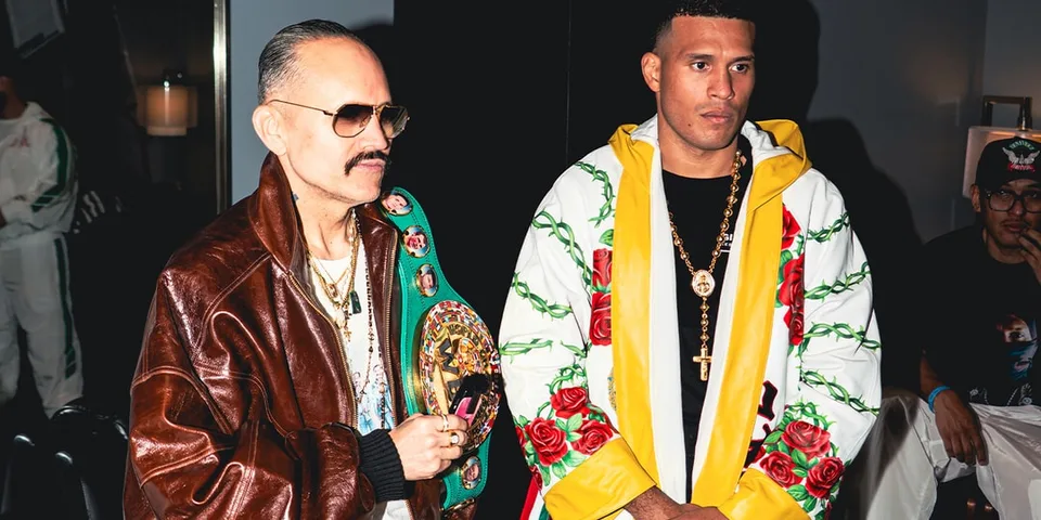 Deux hommes en costumes, l'un avec une ceinture de championnat.
