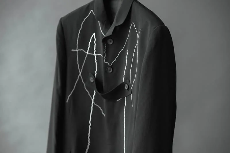 Veste noire avec motifs blancs abstraits sur le devant.