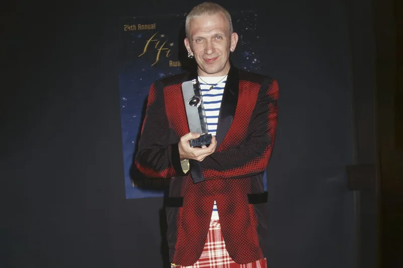 Homme avec un trophée et une veste à carreaux rouges et noirs.