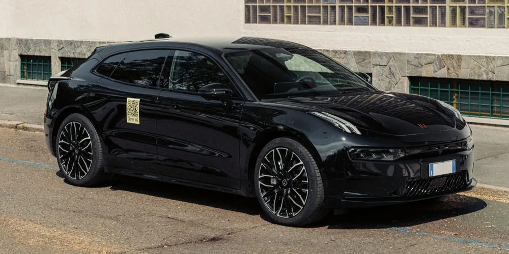 Voiture noire garée près d'un trottoir, design moderne et sportif.