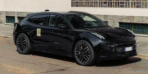Voiture noire garée près d'un trottoir, design moderne et sportif.